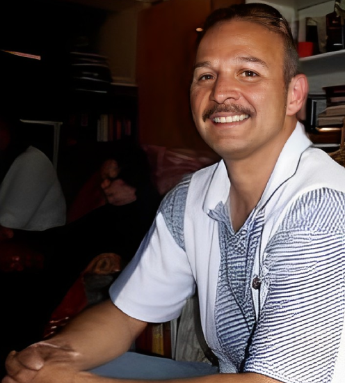 A man sitting at a table in front of a book.